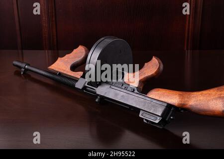 Thompson mitragliatrice su un tavolo scuro stile vintage sfondo fotografia Foto Stock
