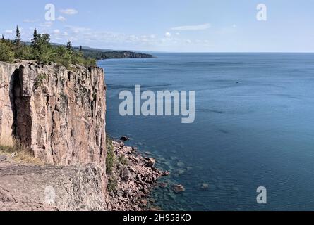 Le scogliere di granito a strapiombo sopra la distesa limpida e blu profondo del lago superiore Foto Stock