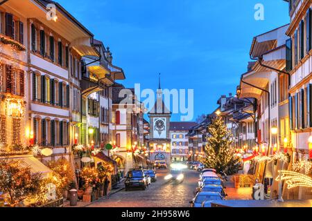 Scena notturna con decorazioni natalizie nel centro storico di Murten (Morat in francese) nel Cantone di Friburgo in Svizzera, lungo la via Hauptgasse con Foto Stock