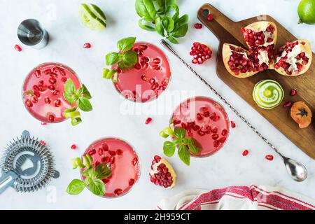 Melagrana cocktail Basil Martini con Lime Twist in bicchieri Coupé sul banco marmo Foto Stock