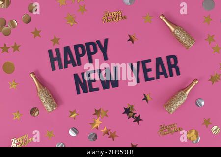 Buon testo di inizio anno circondato da dolci dorati e bottiglie di champagne su sfondo rosa Foto Stock