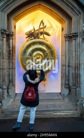 Uno studente straniero cinese scatta una foto al crepuscolo dell'orologio illuminato del Corpus Christi College, Cambridge University, Regno Unito. Foto Stock