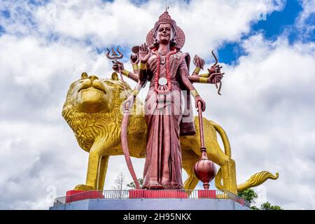 Una potente Statua della dea indù Durga Maa con un leone d'oro nella sacra Ganga Talao. Lago del cratere di Grand bassin, isola di Mauritius. Foto di alta qualità. Foto di alta qualità Foto Stock