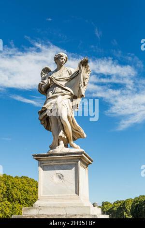 Statua di un Angelo a Castel di Angelo in Vaticano con cielo blu e nuvole bianche Foto Stock