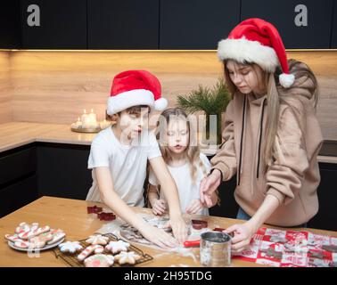 Preparatevi per le vacanze di Natale. I bambini preparano il pan di zenzero in cucina Foto Stock