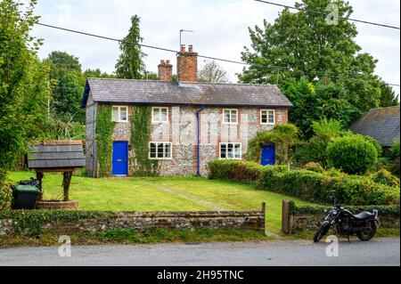 Un tradizionale cottage in pietra focaia e mattoni a Farnham, Dorset, Inghilterra. Foto Stock