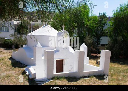 Bella Isola di iOS Grecia. Piccola cappella affascinante in una glata boscosa appartata. Punto di riferimento locale al porto delle isole. Vista dell'aspetto paesaggistico. Foto Stock