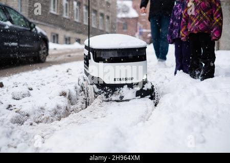 Tallinn, Estonia - 4 dicembre 2021: Veicolo drone autonomo Starship Technologies bloccato nella neve in inverno. Robot di erogazione senza contatto ad azionamento automatico. Foto Stock