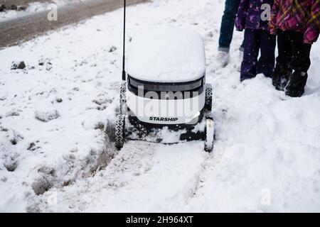 Tallinn, Estonia - 4 dicembre 2021: Veicolo drone autonomo Starship Technologies bloccato nella neve in inverno. Robot di erogazione senza contatto ad azionamento automatico. Foto Stock