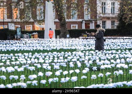 Londra, Regno Unito. 4 Dic 2021. La gente cammina intorno al giardino Ever After, che presenta 25,000 rose bianche che illuminano la Piazza Grosvenor. L'installazione a luce libera sarà aperta fino al 23 dicembre e raccoglie fondi per la Royal Marsden Cancer Charity. I visitatori possono anche dedicare la propria rosa illuminata ad una persona amata, in cambio di una donazione alla carità. Credit: Imagplotter/Alamy Live News Foto Stock