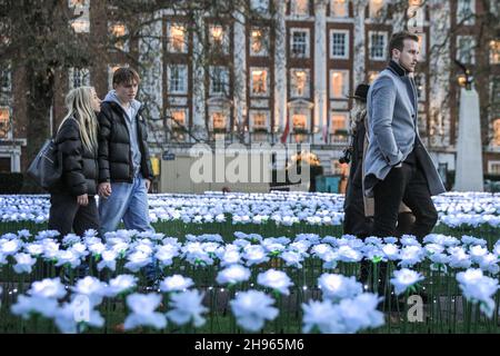 Londra, Regno Unito. 4 Dic 2021. La gente cammina intorno al giardino Ever After, che presenta 25,000 rose bianche che illuminano la Piazza Grosvenor. L'installazione a luce libera sarà aperta fino al 23 dicembre e raccoglie fondi per la Royal Marsden Cancer Charity. I visitatori possono anche dedicare la propria rosa illuminata ad una persona amata, in cambio di una donazione alla carità. Credit: Imagplotter/Alamy Live News Foto Stock