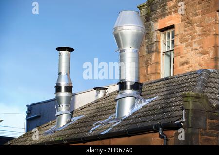 Camino fumi fissata alla costruzione di parete esterna in acciaio inox da scarico impianto caldaia a camera Foto Stock