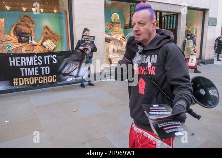 Londra, Regno Unito. Londra, Regno Unito. 4 dicembre 2021. I manifestanti presso il negozio Hermés Mayfair hanno chiesto alla società di abbandonare i suoi piani per espandere massicciamente la sua crudele coltivazione di coccodrilli australiani e si impegnano invece a cambiare in alternative vegetali e sintetiche. La protesta di Fur Free London è stata la terza Giornata Mondiale d'azione contro la loro coltivazione di coccodrilli nelle principali città del mondo. Tre coccodrilli sono uccisi per fare una borsa. Peter Marshall/Alamy Live News Foto Stock