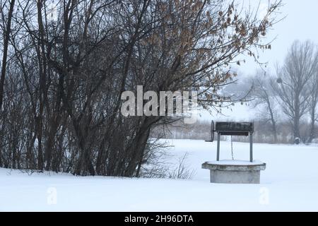 Vecchio abbandonato bene sul campo nevoso. Foto Stock