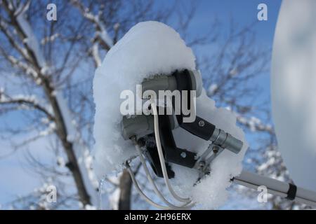 Parabola satellitare coperta di neve Foto Stock