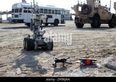 Un robot gestito dal team di smaltimento di Ordnance esplosivo si avvicina a due sistemi aerei senza equipaggio, armati di un dispositivo esplosivo simulato, durante un esercizio alla base aerea di al Dhafra, Emirati Arabi Uniti, 3 dicembre 2021. Il 380° Squadrone delle forze di sicurezza di Expeditionary presso la base ha la responsabilità di contrastare le potenziali minacce UAS. (STATI UNITI Air Force foto di Master Sgt. DaN Heaton) Foto Stock