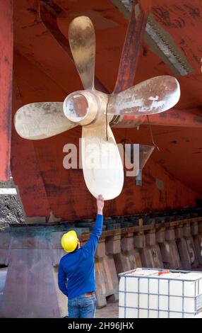 Ispezionare l'elica della risoluzione HMNZS in bacino asciutto alla base navale di Devonport ad Auckland, Nuova Zelanda Foto Stock
