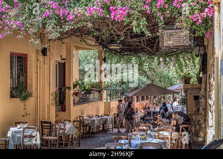 Turisti che hanno cenato sotto la bouganvillea nella città vecchia di Chania, Creta, Grecia, 18 ottobre 2021 Foto Stock