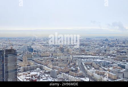 Vista dall'alto di Mosca in una giornata invernale. Le aree urbane e le autostrade sono coperte di neve. La vita quotidiana della città. Foto Stock