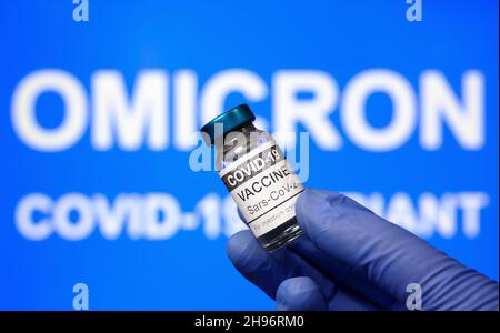 Omicron COVID-19 variante e vaccino corona virus, focalizzato sul flaconcino di vaccino. Concetto di salute, nuovo ceppo di coronavirus, ricerca sui vaccini, riapertura, globo Foto Stock