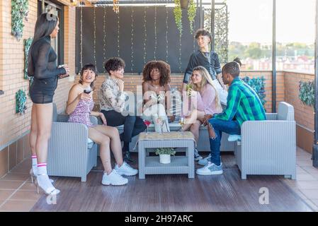 Amici multietnici su una terrazza per un buon momento Foto Stock