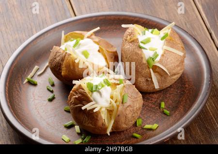Patate al forno con erba cipollina, formaggio e panna acida Foto Stock