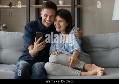 Felice coppia sposata allegra che parla di videochiamata sullo smartphone Foto Stock