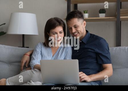 Sorridente coppia sposata rilassata utilizzando l'app ecommerce per lo shopping online Foto Stock
