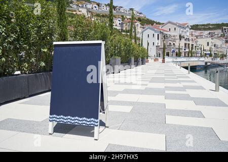 Lavagna bianca con marciapiede pubblicitario nella città europea. Foto Stock