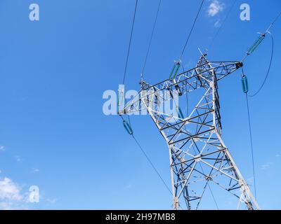 Un'inquadratura a basso angolo di un pilone elettrico contro un cielo blu Foto Stock