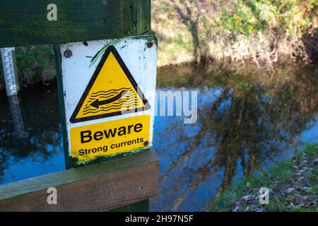 Un segnale di avvertimento che dice ai passanti di fare attenzione alla forte corrente alla stazione di misura di Stapleford sul fiume Granta. Foto Stock