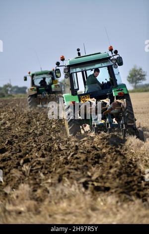 trattori vintage che arano insieme Foto Stock