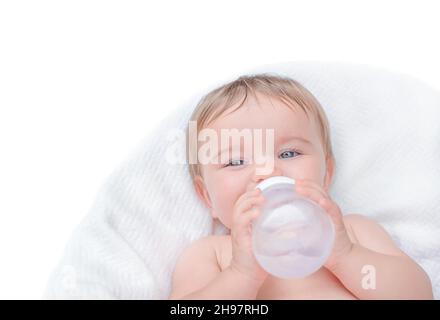 Il bambino beve da un biberon. Bambino che tiene la bottiglia d'acqua isolato Foto Stock