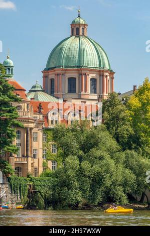 La cupola verde alta 40 metri e la cupola della neoclassica Chiesa di San Francesco d'Assisi di Jean-Baptiste Mathey si affacciano sul fiume Moldava di Praga. Foto Stock