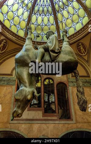 La statua di David Černý del 1999 'Kun' (cavallo), ha il re Venceslao che guida un cavallo morto capovolto, nel Palazzo Lucerna in Piazza Venceslao Foto Stock