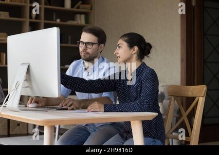 Due colleghi multietnici focalizzati che lavorano insieme al progetto Foto Stock