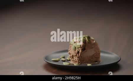 gelato al cioccolato con semi di zucca su piattino su tavola di legno, foto ampia Foto Stock