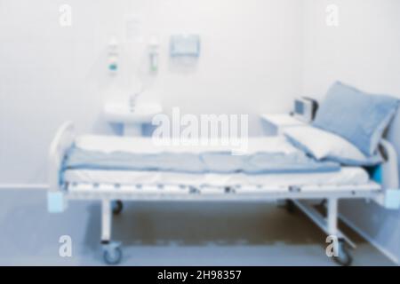 Foto sfocata della sala operatoria in ospedale. Apparecchiatura chirurgica con tavolo operatorio. Dispositivo medico per pazienti di emergenza in stile blu Foto Stock