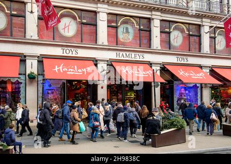 4 dicembre 2021: Shopping natalizio presso il famoso negozio di giocattoli Hamleys di Regent Street, Londra. Il governo del Regno Unito ha riimposto misure che lo rendono un requisito legale per indossare i rivestimenti per il viso nei negozi e sui trasporti pubblici, a meno che non sia esente dal 30 novembre in mezzo a preoccupazioni per la variante Omicron del covid-19. Londra, Regno Unito. Foto Stock