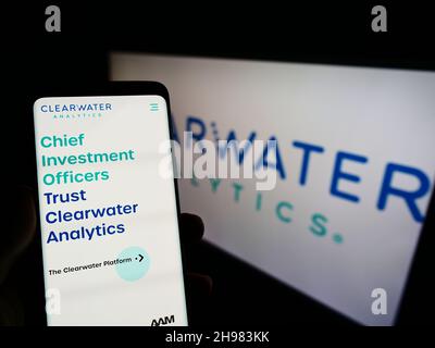 Persona che detiene il cellulare con il sito web della società di Fintech degli Stati Uniti Clearwater Analytics Holdings Inc. Su schermo con il logo. Concentrarsi sul centro del display del telefono. Foto Stock