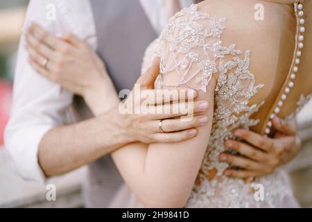 Abbraccia lo sposo e sposa in un abito in pizzo. Primo piano Foto Stock