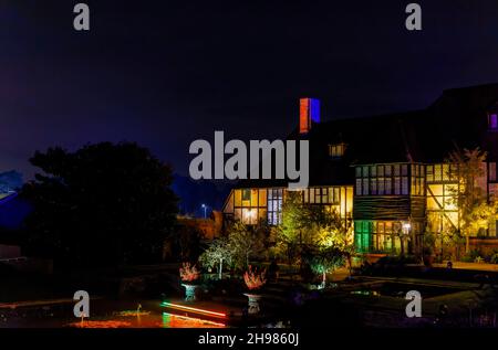 Il laboratorio edificio e il canale Jellicoe illuminato a Glow 2021, l'evento annuale di illuminazione natalizia al RHS Garden Wisley, Woking, Surrey Foto Stock