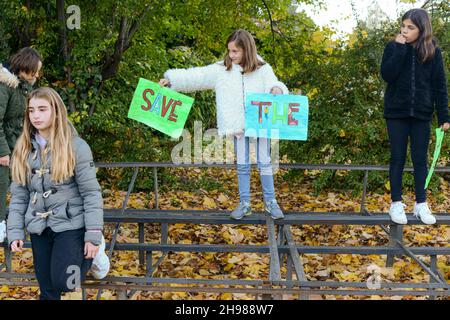 Ecologisti bambini che giocano per salvare il pianeta come inquinamenti tossici malvagi la terra rappresentata dall'attrice viola persona Antonia Stradivari Foto Stock