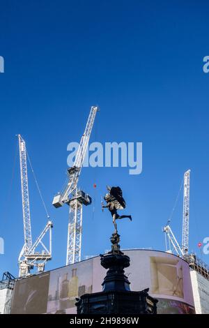 La famosa statua di Eros vista sullo sfondo delle gru a torre, in un cantiere di Piccadilly Circus nel West End di Londra, Regno Unito Foto Stock