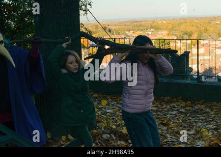 Ecologisti bambini che giocano per salvare il pianeta come inquinamenti tossici malvagi la terra rappresentata dall'attrice viola persona Antonia Stradivari Foto Stock