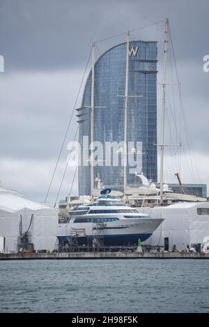 Barcellona, Spagna - 24 Nov, 2021: Superyacht e barche in barca a vela nel cantiere di Barcellona con l'hotel W sullo sfondo Foto Stock