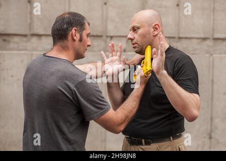 L'istruttore di Kapap dimostra le tecniche di autodifesa contro una pistola Foto Stock