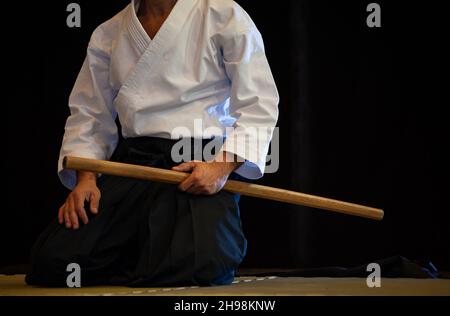 Aikido della cintura nera master durante una sessione di allenamento. Sfondo nero. Foto Stock