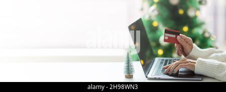 Giovane donna che paga on-line con carta di credito, shopping di vacanza. Persona che utilizza la tecnologia. Banner orizzontale lungo per web design con spazio di copia Foto Stock