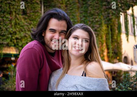 Bella coppia che viaggia a Roma. Una giovane coppia prende un selfie in una strada nel centro storico. Sullo sfondo un edificio coperto di edera. Foto Stock